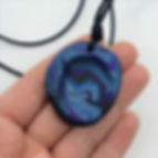 A worry stone necklace being held in an open hand