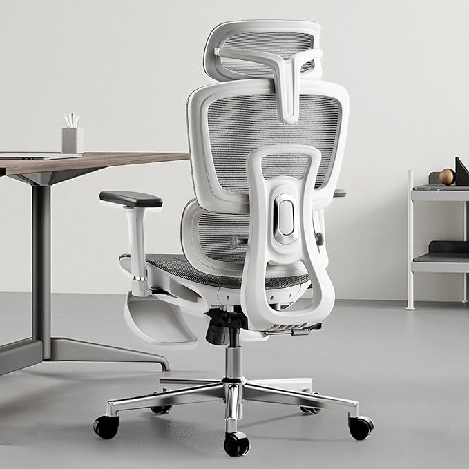 Ergonomic white office chair, back view. Modern design, mesh back, adjustable armrests, desk in the background.
