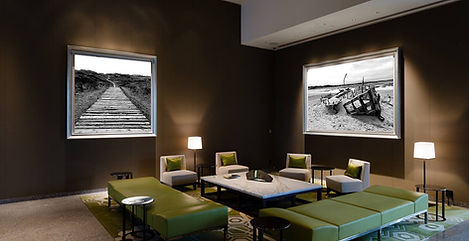 2 black and white framed pictures on dark walls in living room. Interior design