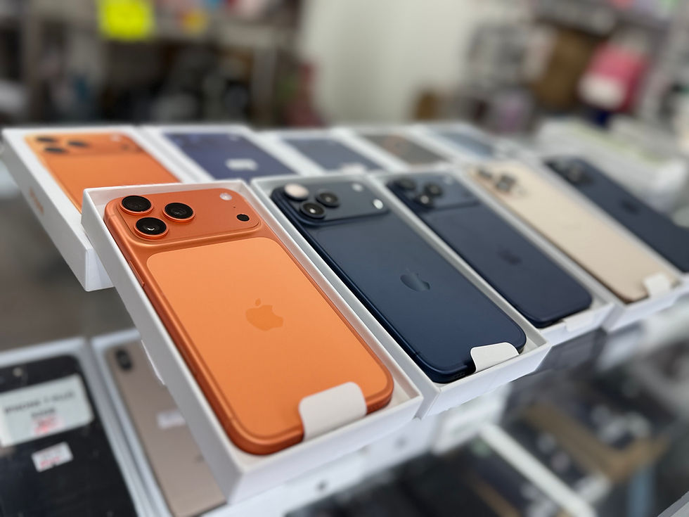 Row of boxed iPhones on a glass counter, with an orange iPhone in front