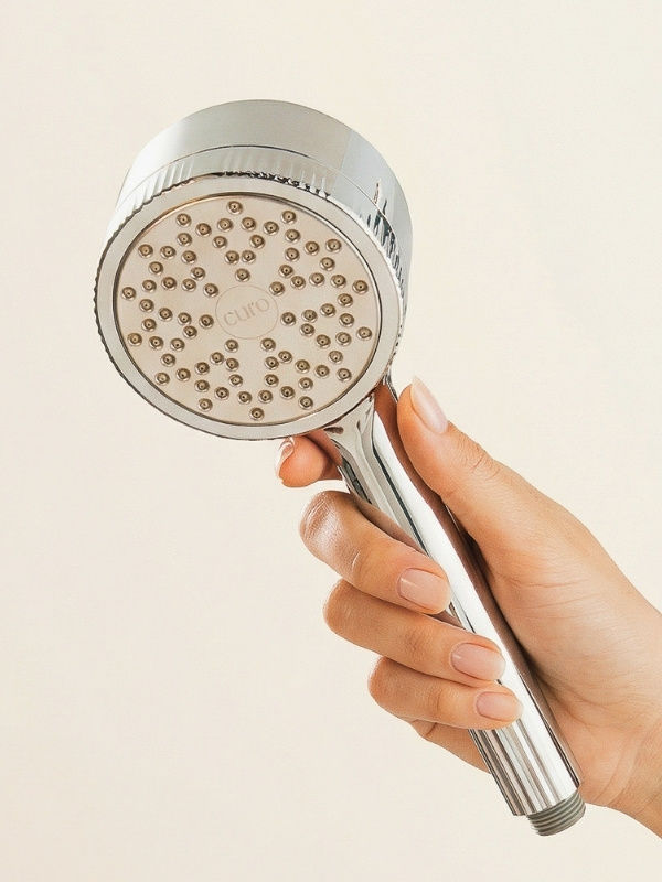 person holding curo skin shower filter head