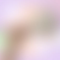 Hand holding a shower filter against a pastel abstract background with question mark graphics, representing things to consider before buying a shower filter for hard water.