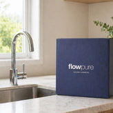 FlowPure water filter box on a kitchen countertop next to a sink and tap in a bright modern kitchen