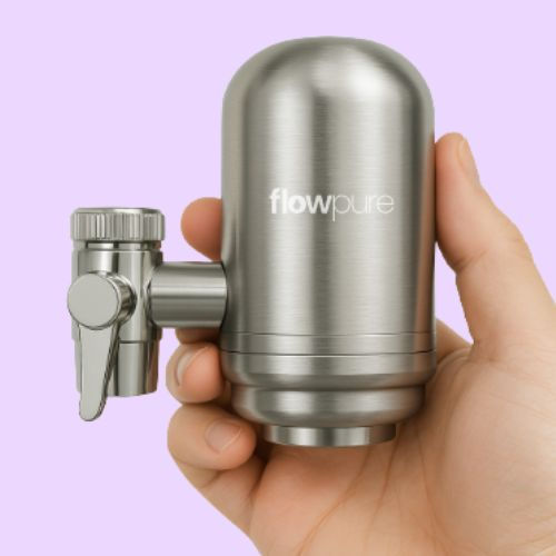 FlowPure stainless steel on-tap water filter held in hand showing the compact metal faucet filter design