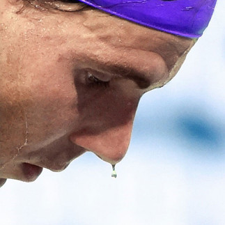 A side-angle photo of Rafael Nadal taken from the service line