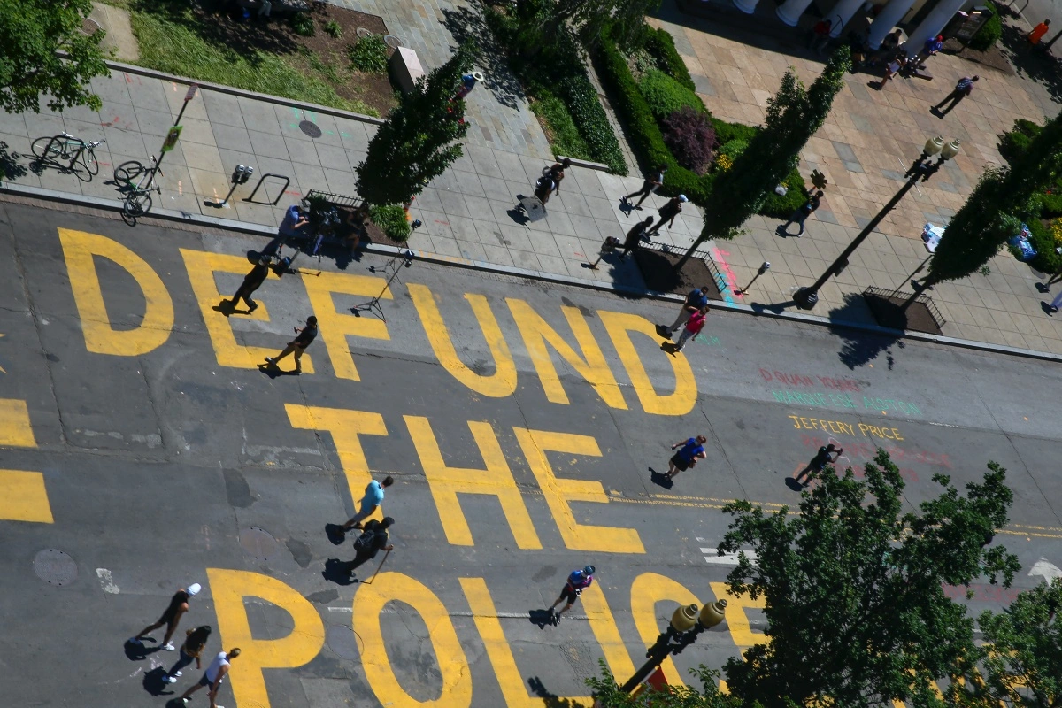 A street painting that reads "Defund the Police"