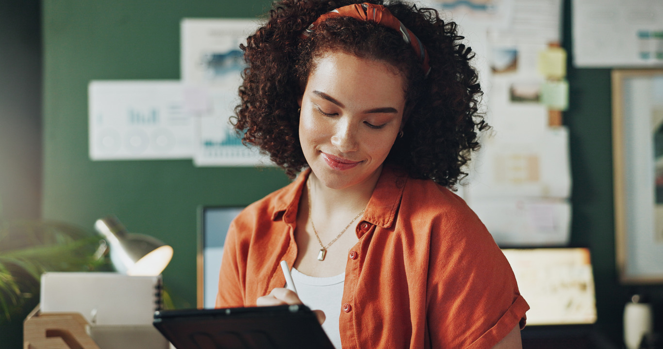 Woman working joyfully on a tablet in front of green wall My Site 2