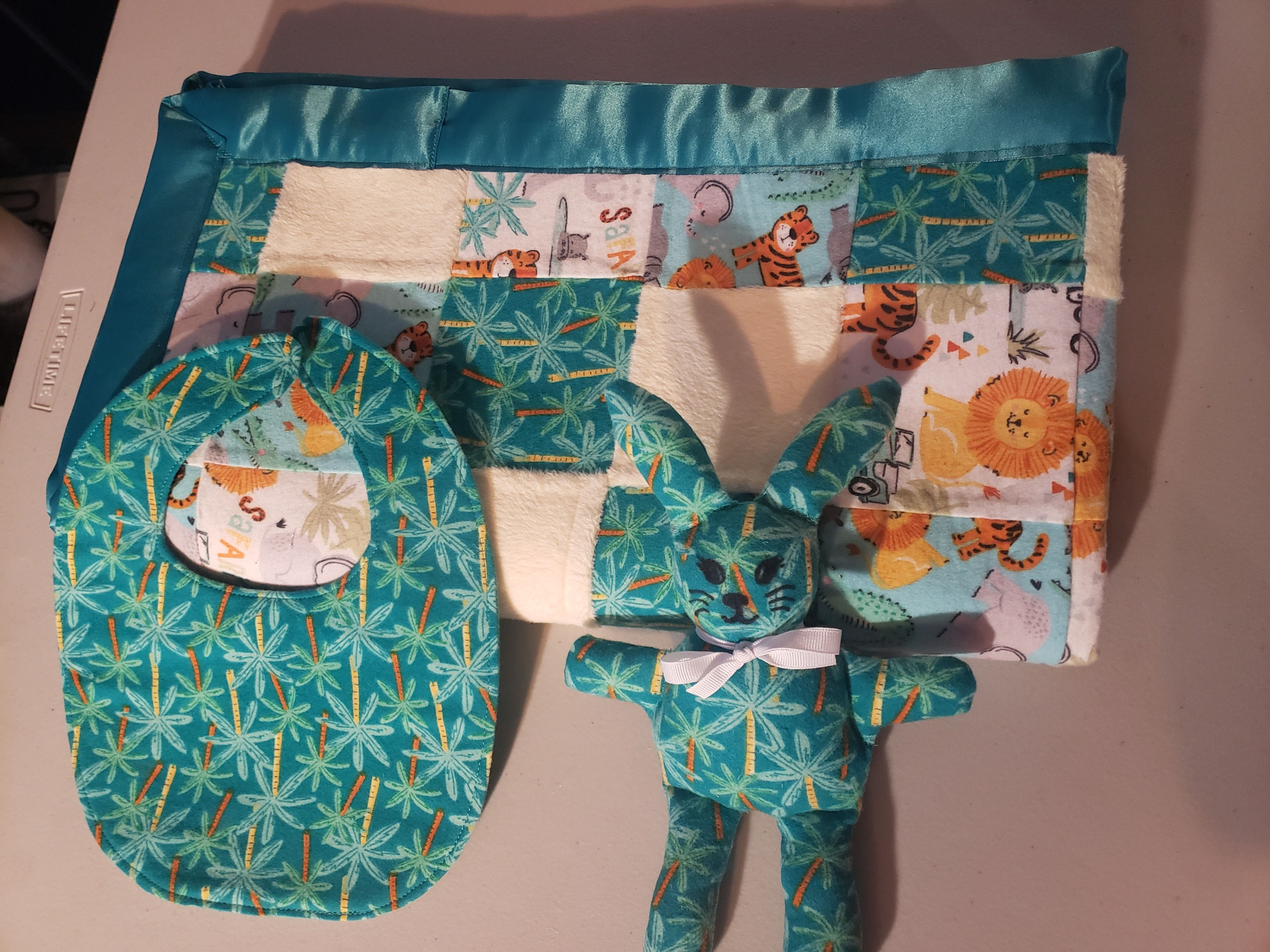 teal jungle design baby set blanket, stuffed animal, bibs