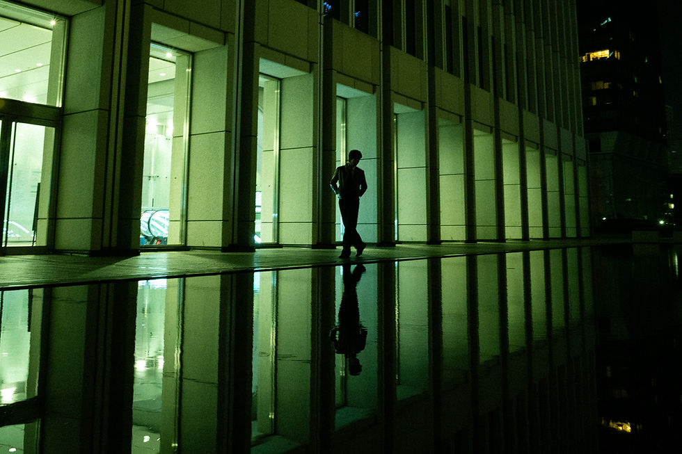 Tokyo photographer captures a man's reflection by a building