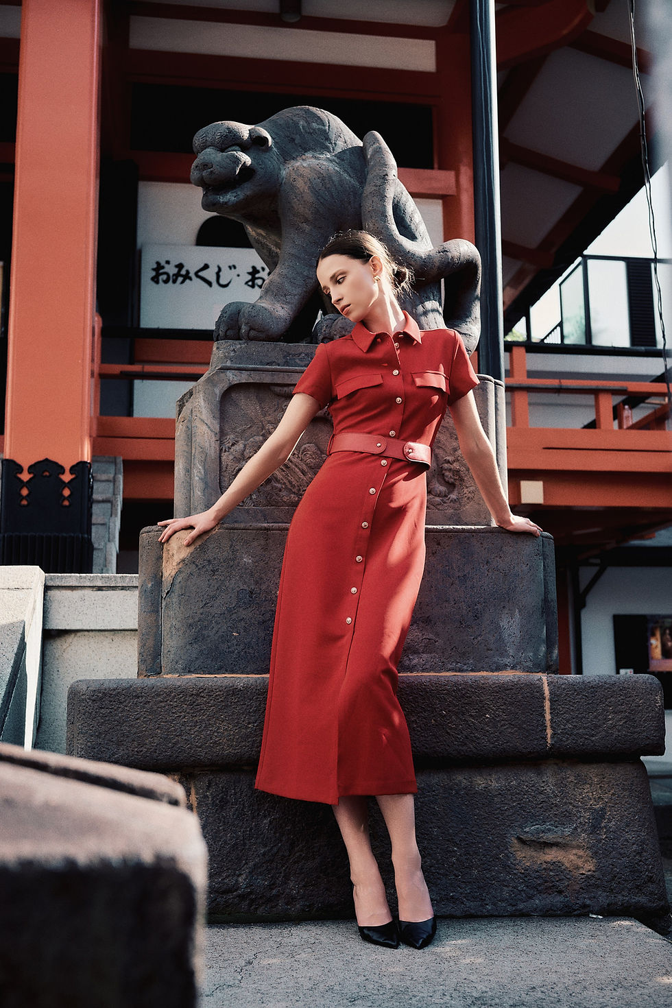 Model in red dress at a Tokyo temple by a videographer.