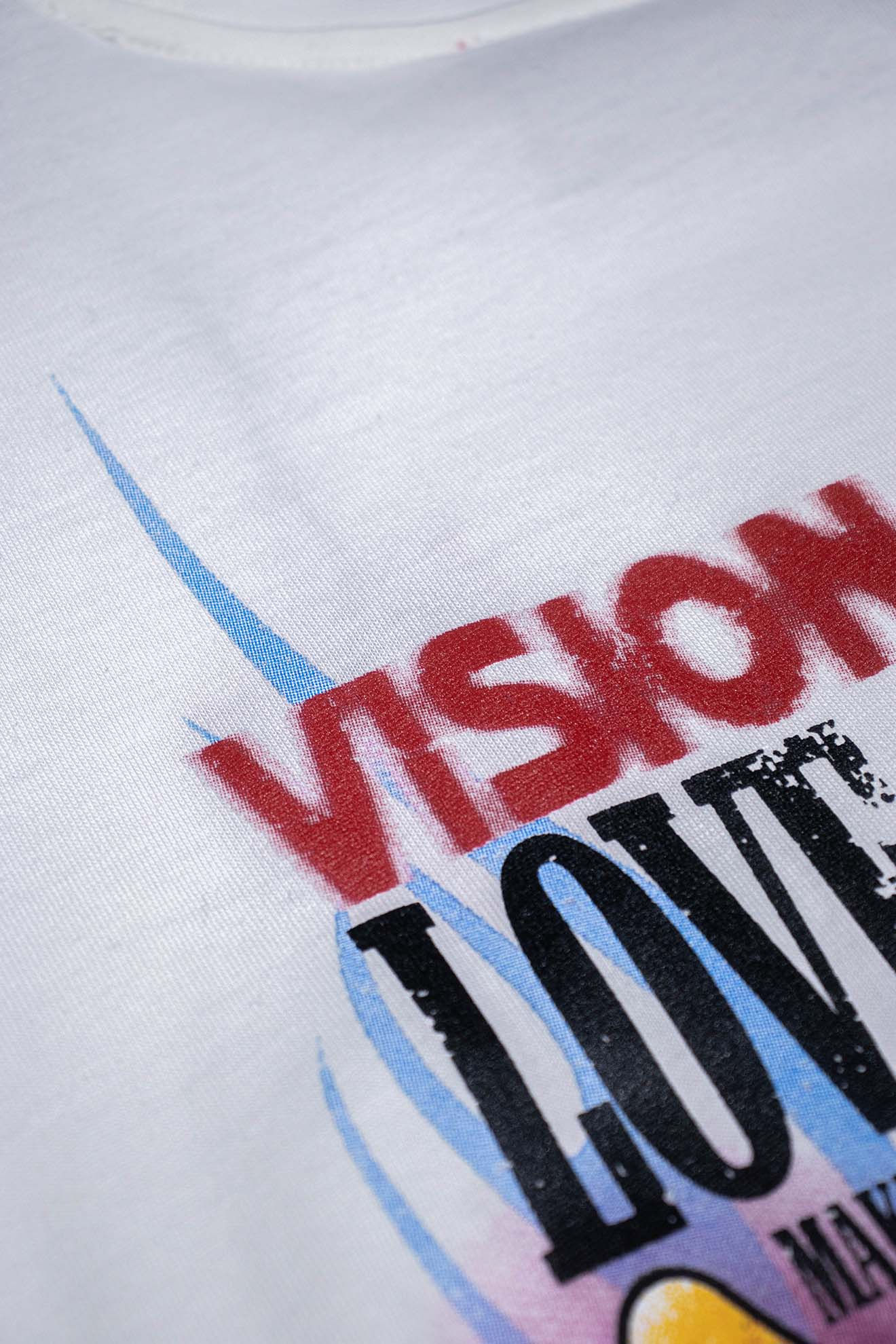 Áo thun trắng có chữ VISION OF SUPER và đồ họa màu sắc.