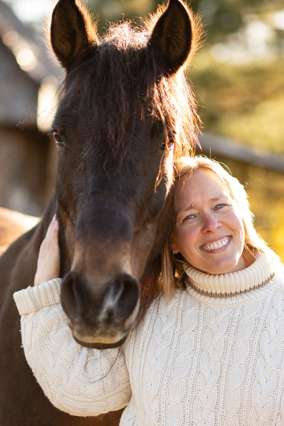 Véronique souriante avec son cheval, dehors au soleil
