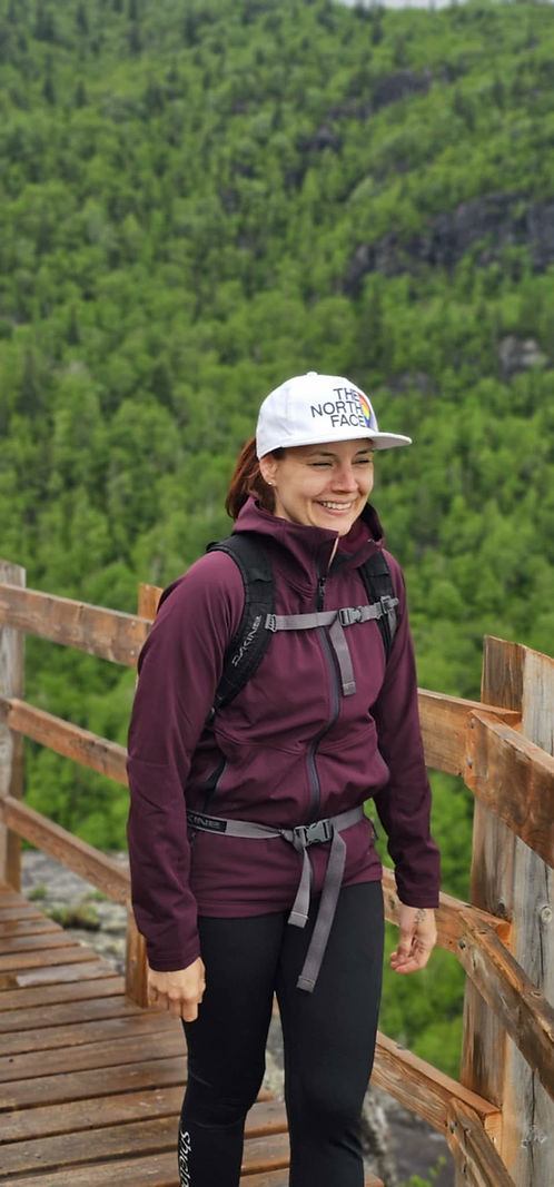 Marie-Noël Côté, fondatrice de Canopée Bus café, sourit sur une passerelle de bois en pleine forêt au Saguenay