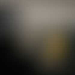 Ultra-realistic image of a yellow banana displayed on a transparent acrylic base, representing Google's Gemini 2.5 AI model 'Nano Banana', with a faceless silhouetted person in the foreground and a computer desk in the background—symbolizing the viral success of AI-generated 3D figurines in 2025.