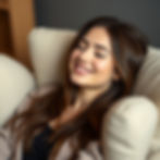 woman in a hypnotic state sat in a comfy chair with a smile and eyes closed