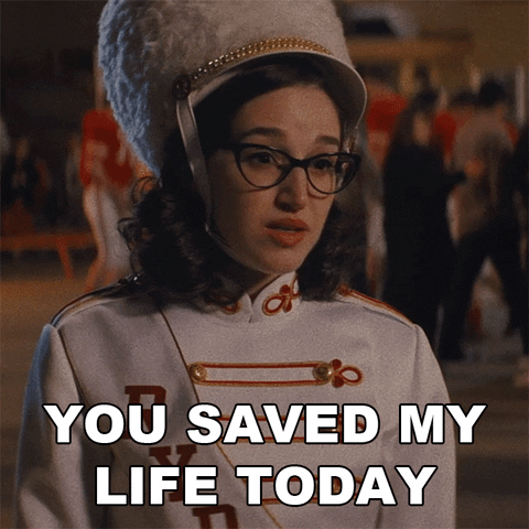 A person in a band uniform with a tall hat looks emotional. Text reads "YOU SAVED MY LIFE TODAY." Blurred background with people.