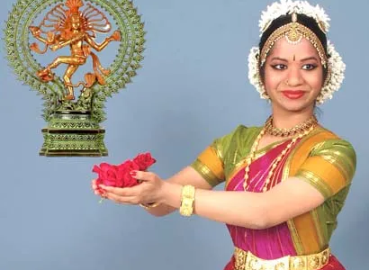 Photo of Diya in her Bharatanatyam costume offering flowers to Lord Nataraja and smiling