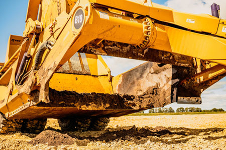 K-tec Scraper being hauled by a green tractor on a mine site