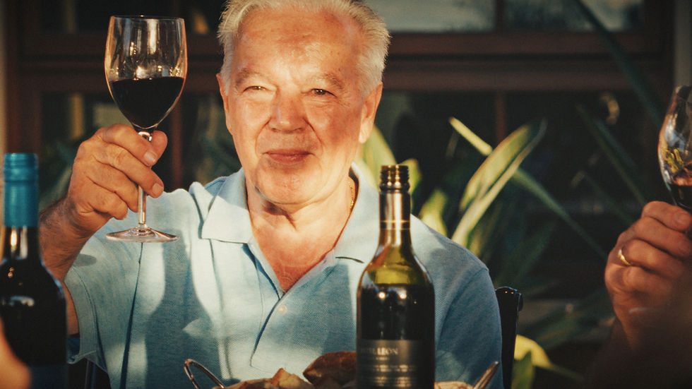 Older man toasting with a glass of red wine