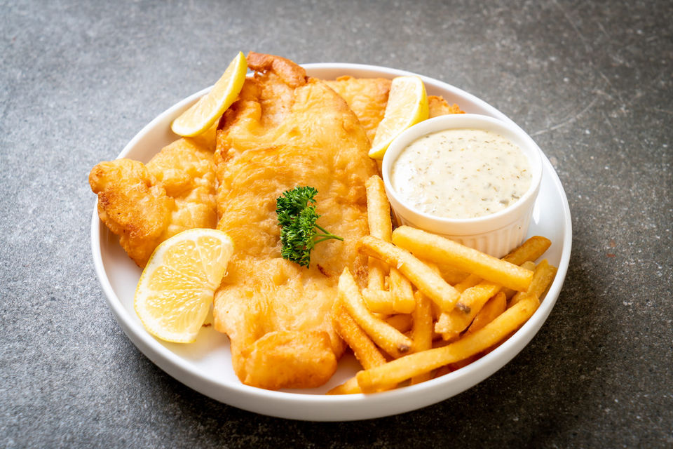 Fish and chips with lemon wedges and sauce