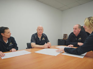 Barnetts Architectural Hardware team reviewing project plans together around a table at their Perth office