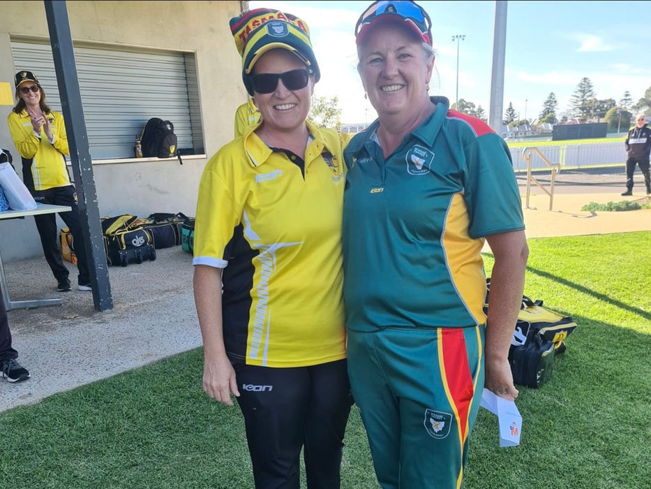 Two women in team uniforms smiling
