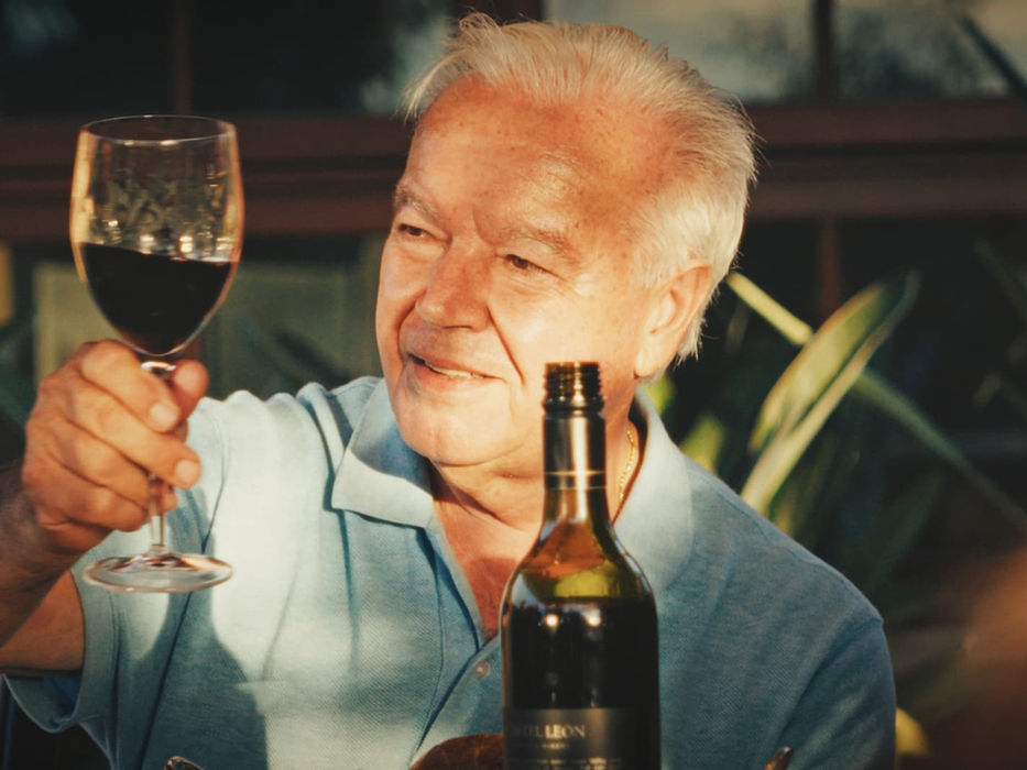 Smiling man holding a glass of red wine