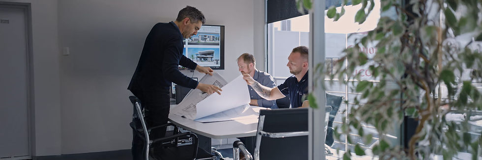 Team reviewing blueprints during meeting