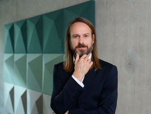 Philipp Baaske standing in front of a wall reflecting on 17 years of leadership experience.