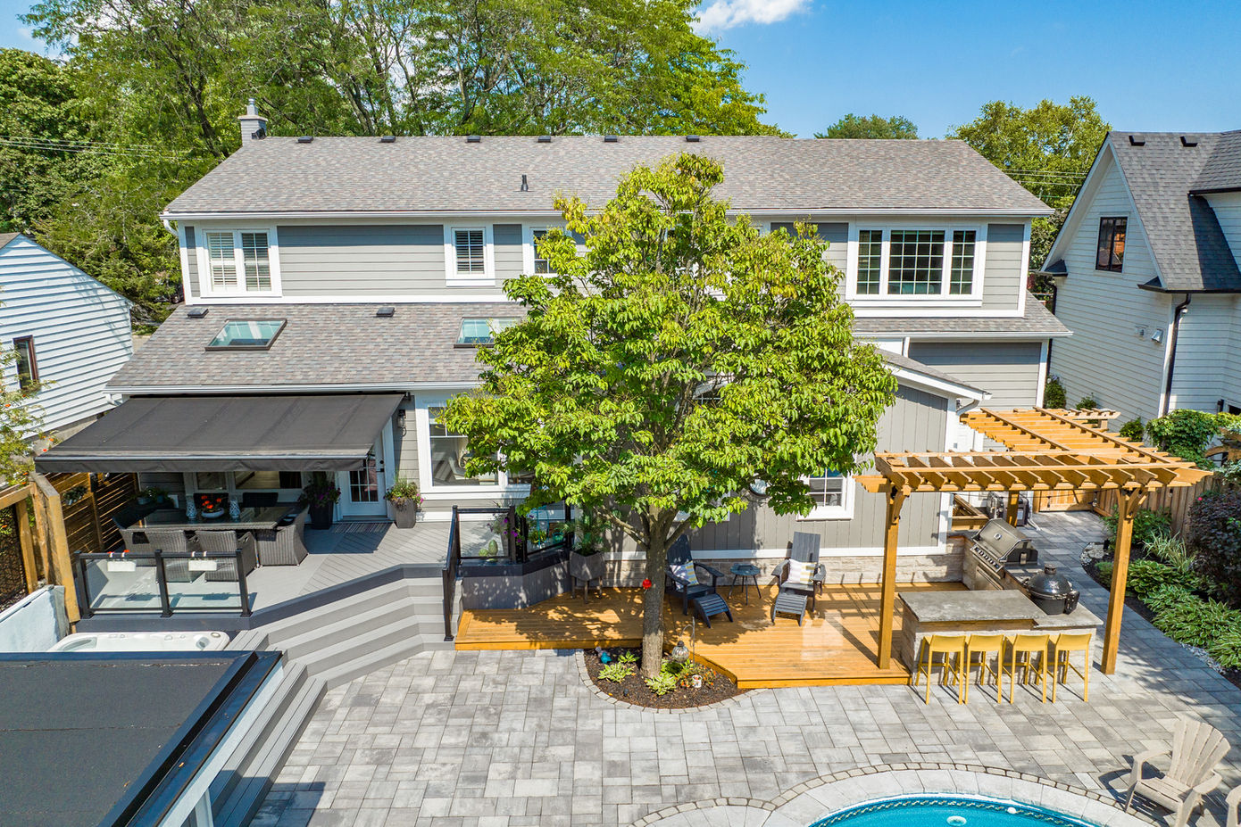 Backyard oasis: gray house, deck, pergola, pool
