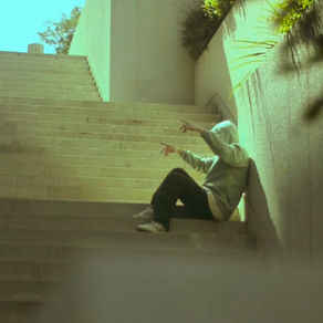 Rapero EneHHe sentado en escalera por santiago con estilo urbano