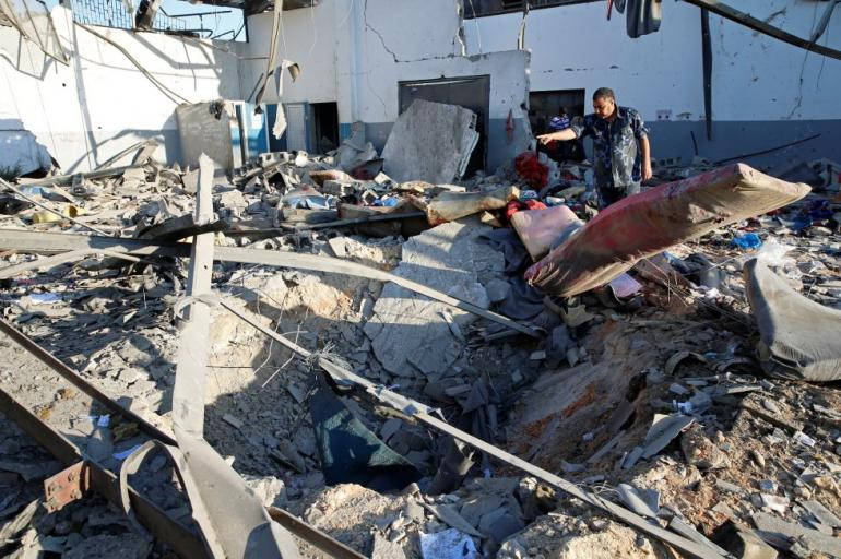Militares del Gobierno Libio de Acuerdo Nacional (GNA) inspeccionan los daños y escombros en un centro de detención de migrantes después del bombardeo. Foto: Mahmud Turkia / AFP