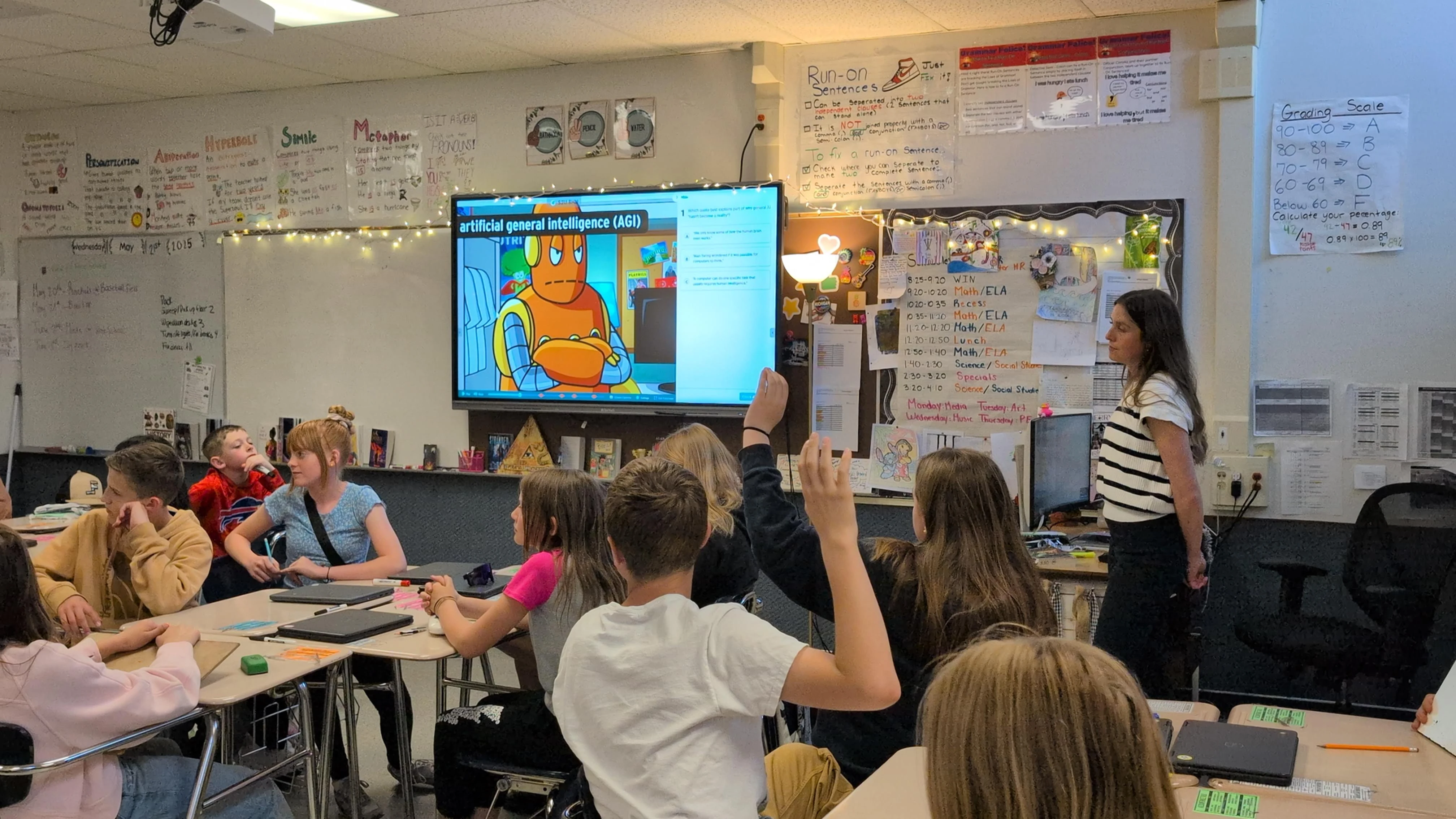 Students watching a BrainPOP movie on Artificial Intelligence together, raising hands to answer questions on the screen.