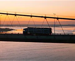 Drone shot of a lorry crossing the Humber Bridge at sunset over the River Humber.