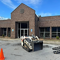 Bobcat machine parked in front of the Elizabethton Post Office, ready for tree work.