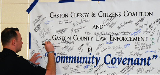 A man signing the law enforcement covenant.