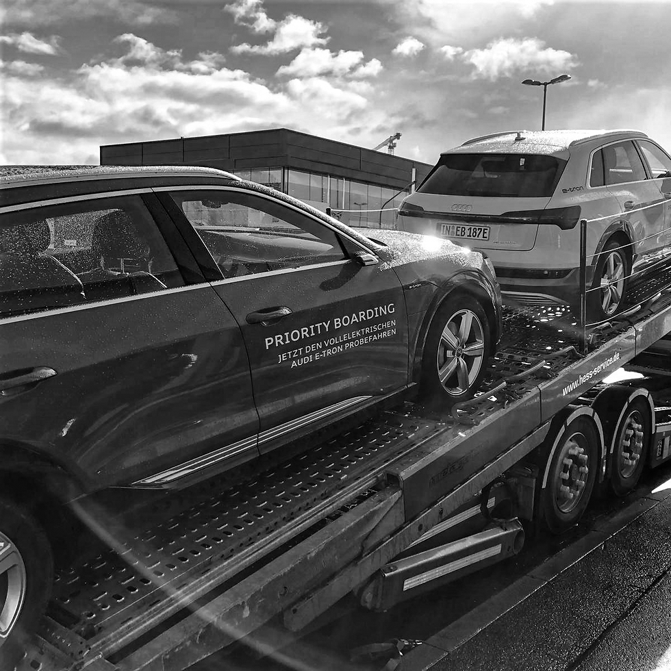 Schwarzweißbild von Fahrzeuganlieferung Audi e-tron auf Transporter für Priority Boarding