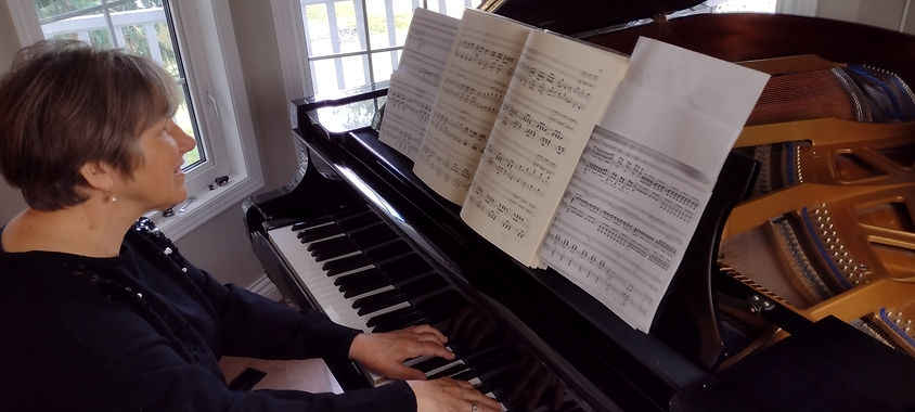 Susan at piano in front of sheet music.
