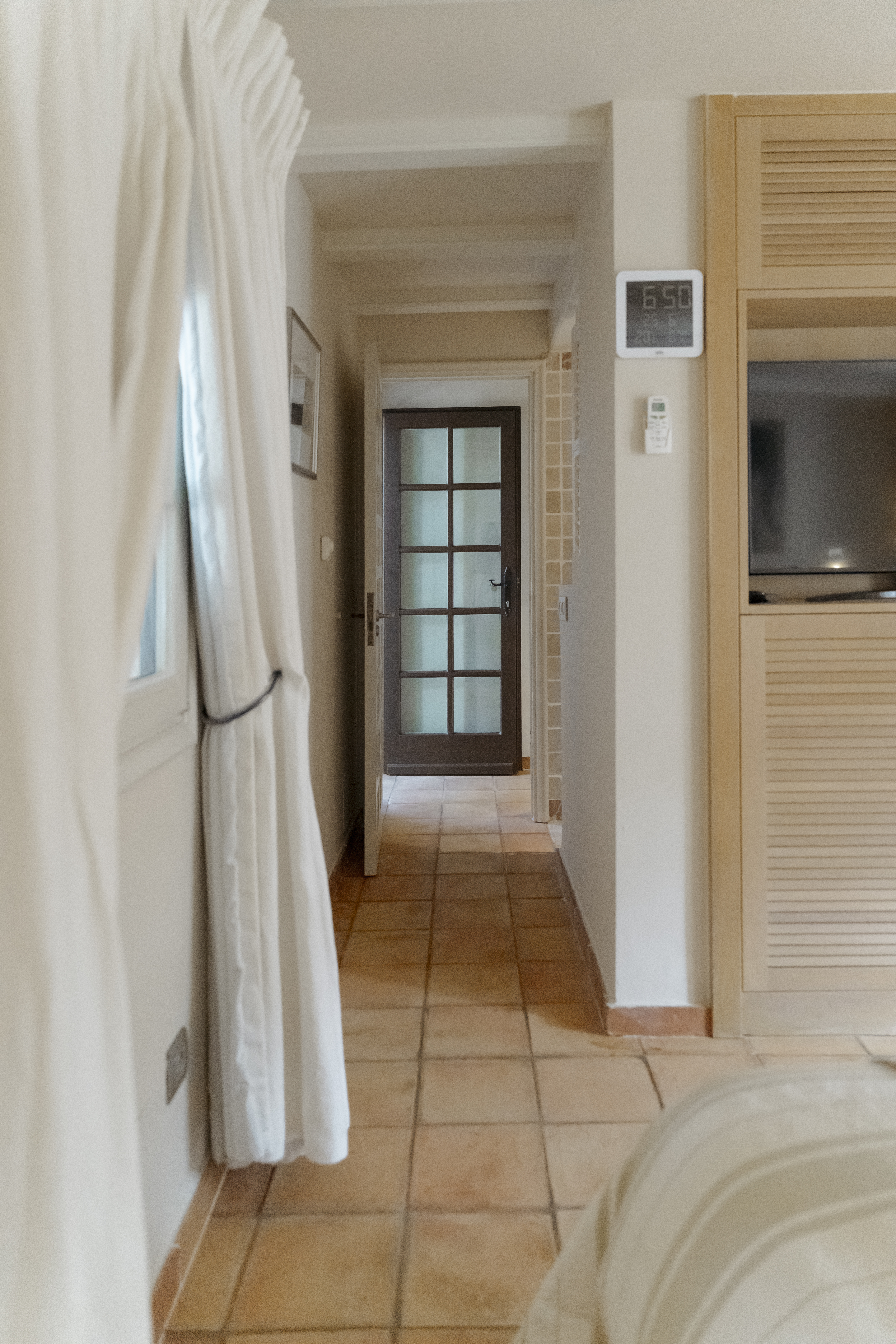 Bright and elegant interior hallway of a Mediterranean villa with terracotta tile flooring.