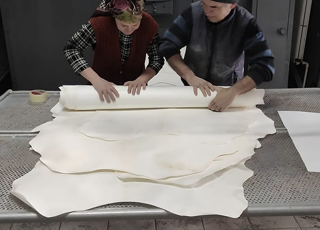 Workers rolling parchment hides