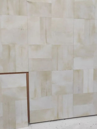 Close up view of a large parchment wall panel during installation.