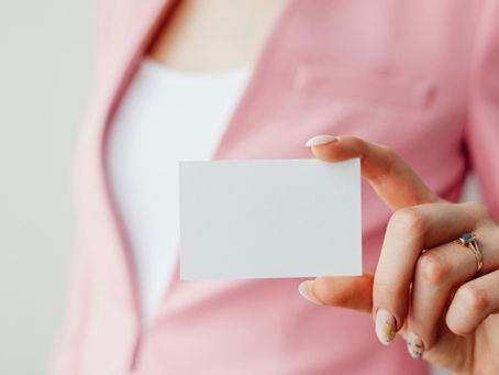 persona sosteniendo una tarjeta de presentacio