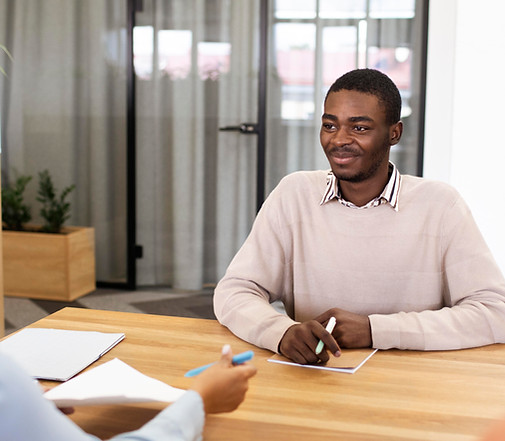 Man Sitting Down At Desk in Interview
