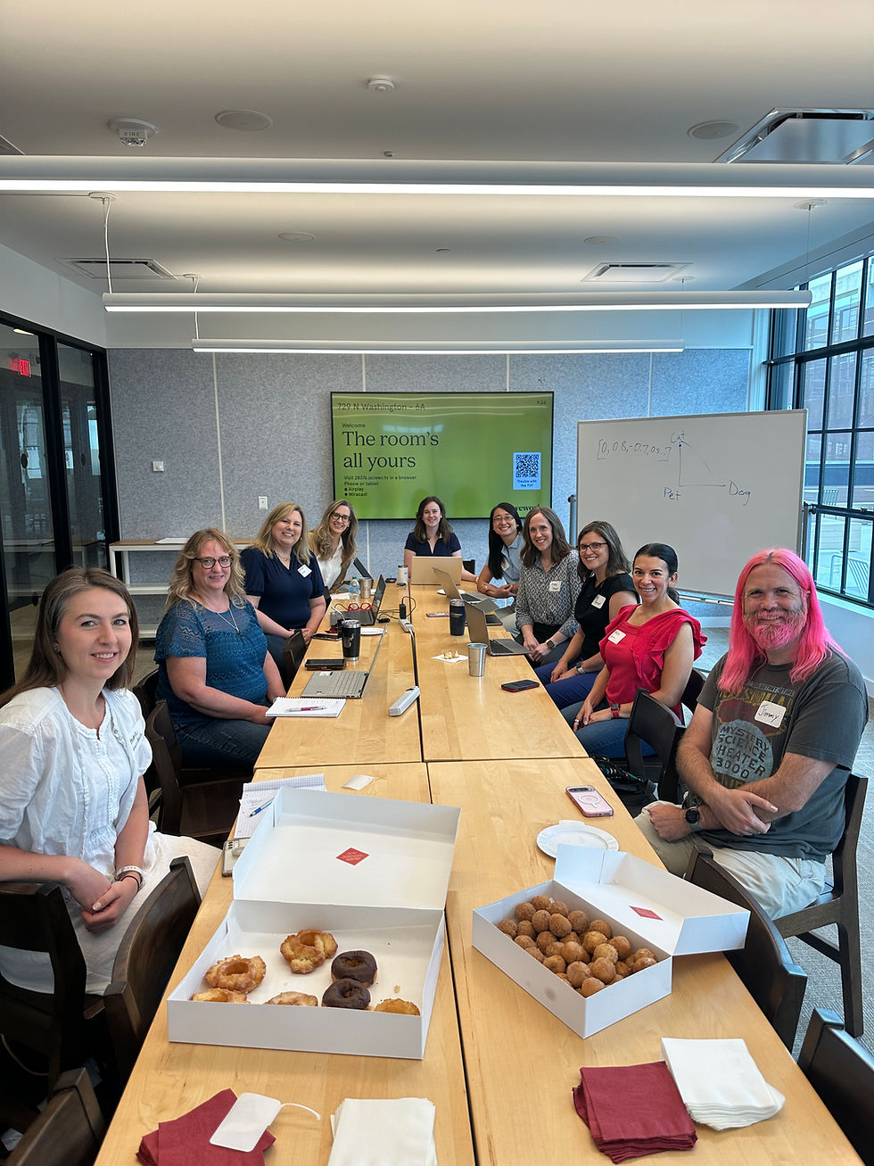 A group of MN Women in AI members at an AI Study Group table with doughnuts