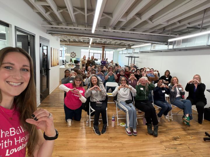 Jena Zangs takes a selfie with a group of MN Women in AI members at a vibe coding hackathon.