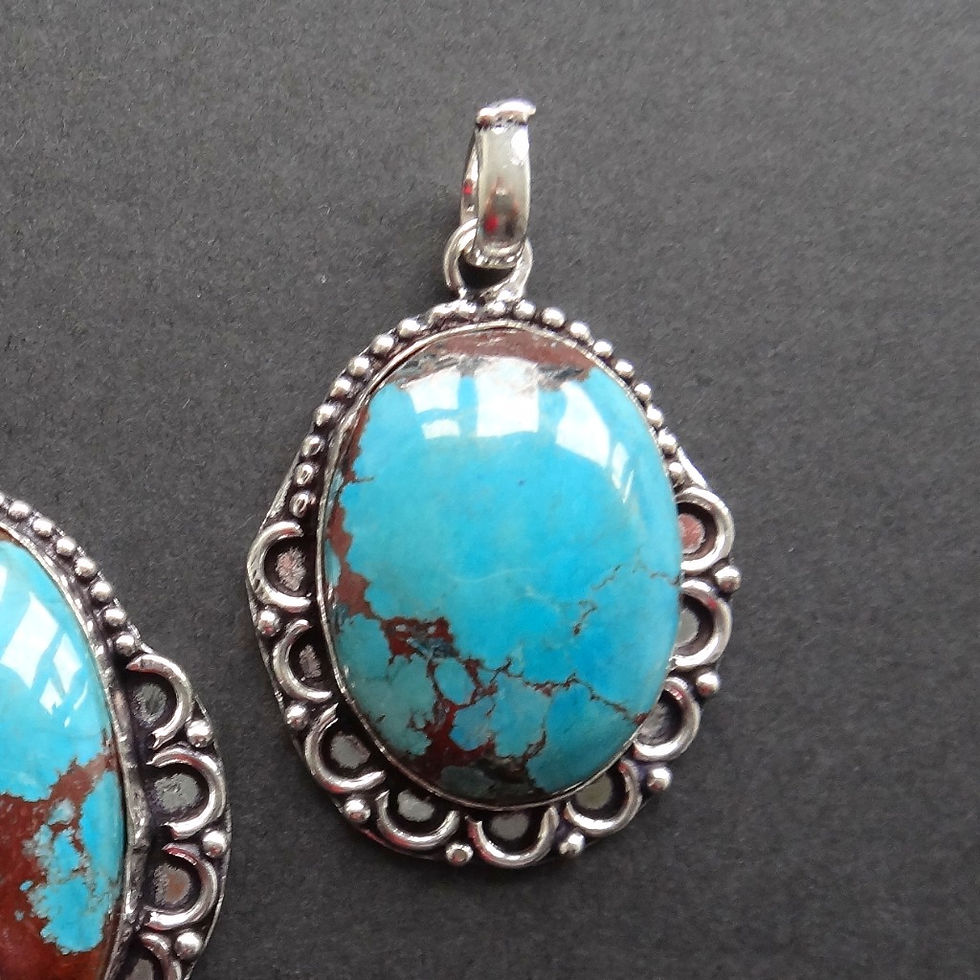 Thumbnail: Silver plated necklaces feature an oval turquoise howlite gemstone, hand set within a floral silver setting.