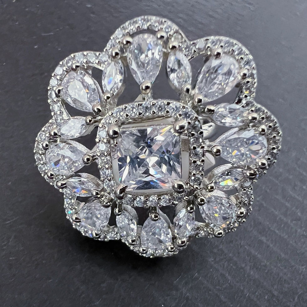 Thumbnail: Large ring featuring 8 petals set with tiny stones, a central square crystal stone surrounded by teardrop shaped crystals.
