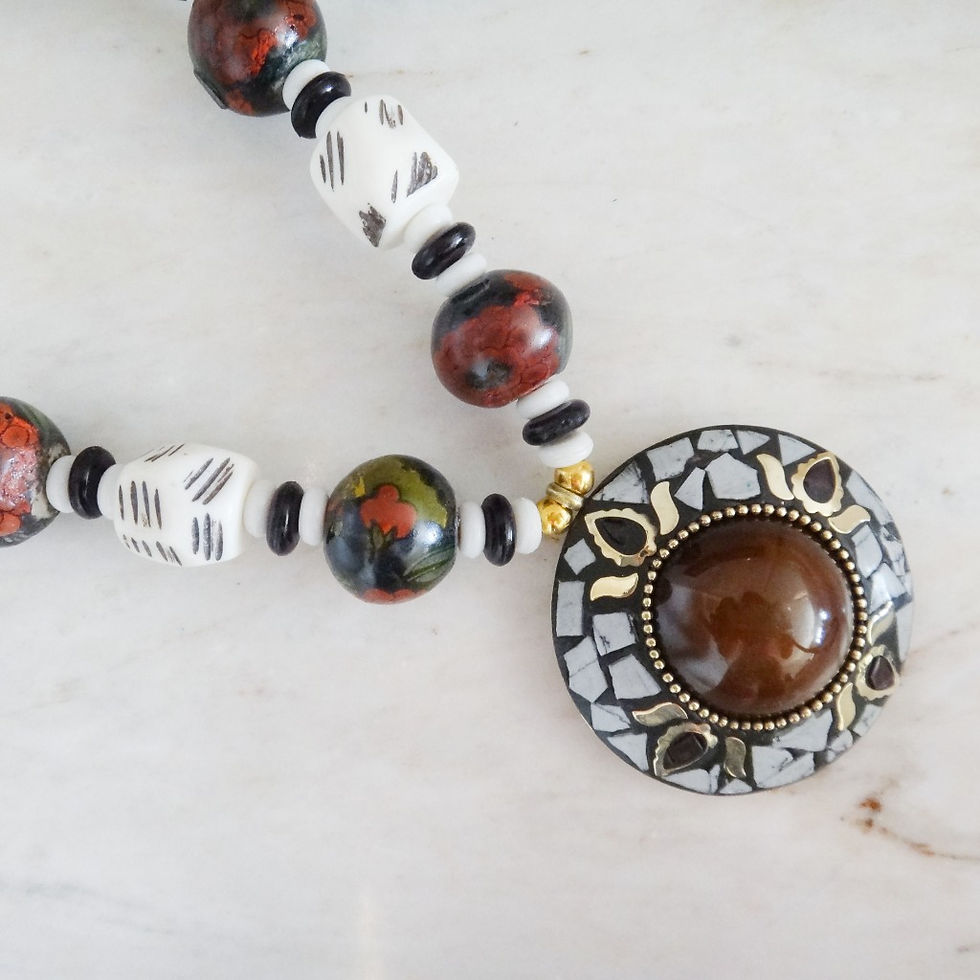 Thumbnail: A chunky necklace with shades of brown beads, some hand-painted, and a round pendant with a polished centre large brown stone