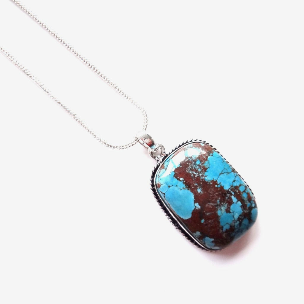 The sterling silver plated necklace features a rectangle turquoise howlite gemstone, hand set within a detailed silver-plated