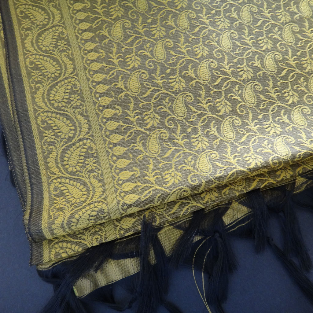 Handwoven Paisley Silk Scarf - Grey & Gold  small, boldpaisley motifs against a soft grey background with black fringe ends.
